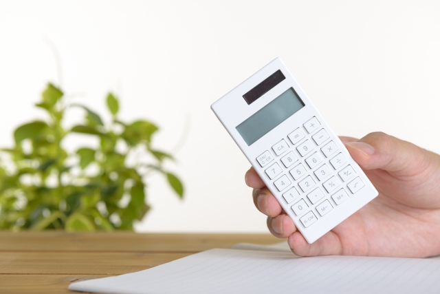 手に電卓を持つ