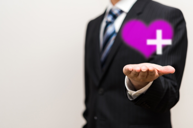 手のひらにハートを乗せたビジネスマン